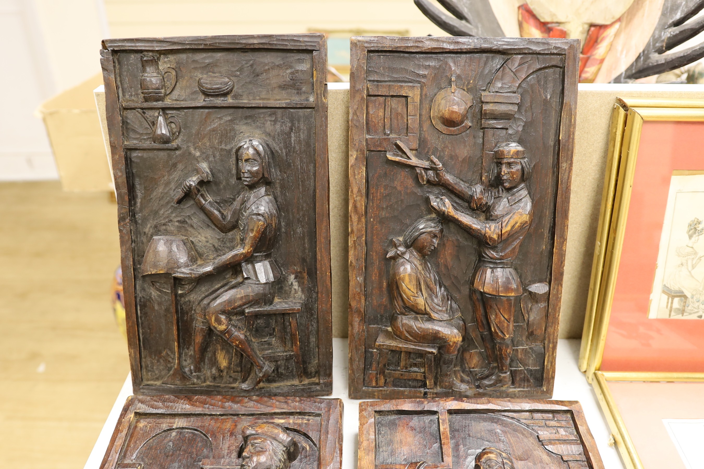 A set of four carved and stained pine figurative panels, 39cms high x 23cms wide